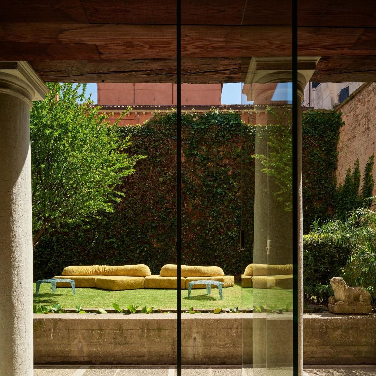  On the Rocks Outdoor e Veronica. 
Il divano rivestito in Every Stone Royal Yellow e i coffee table nel giardino progettato da Carlo Scarpa. 
