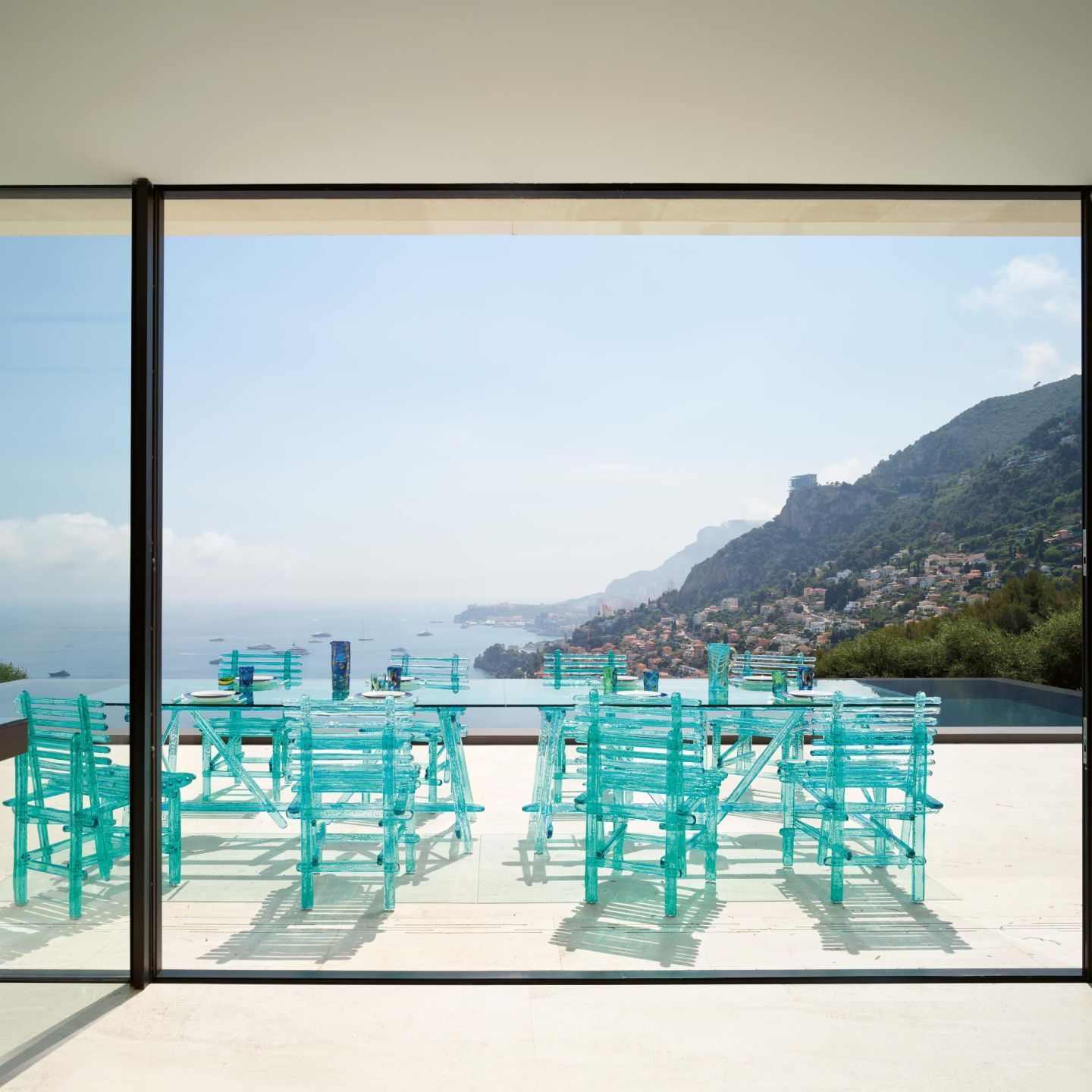  Le sedie e il tavolo della collezione  A'mare  sul solarium della piscina a sfioro 