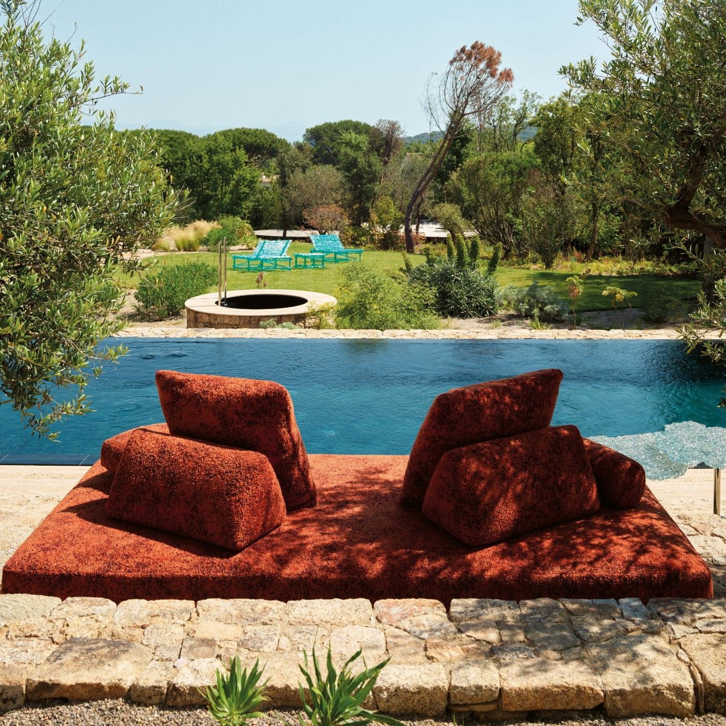  Sherazade outdoor, Diamante, A&rsquo;mare. Il divano outdoor in Every Stone Imperial Red &egrave; affiancato dai tavoli composti da fili di policarbonato &lsquo;intrecciati&rsquo; a mano. Sullo sfondo i lettini prendisole. 