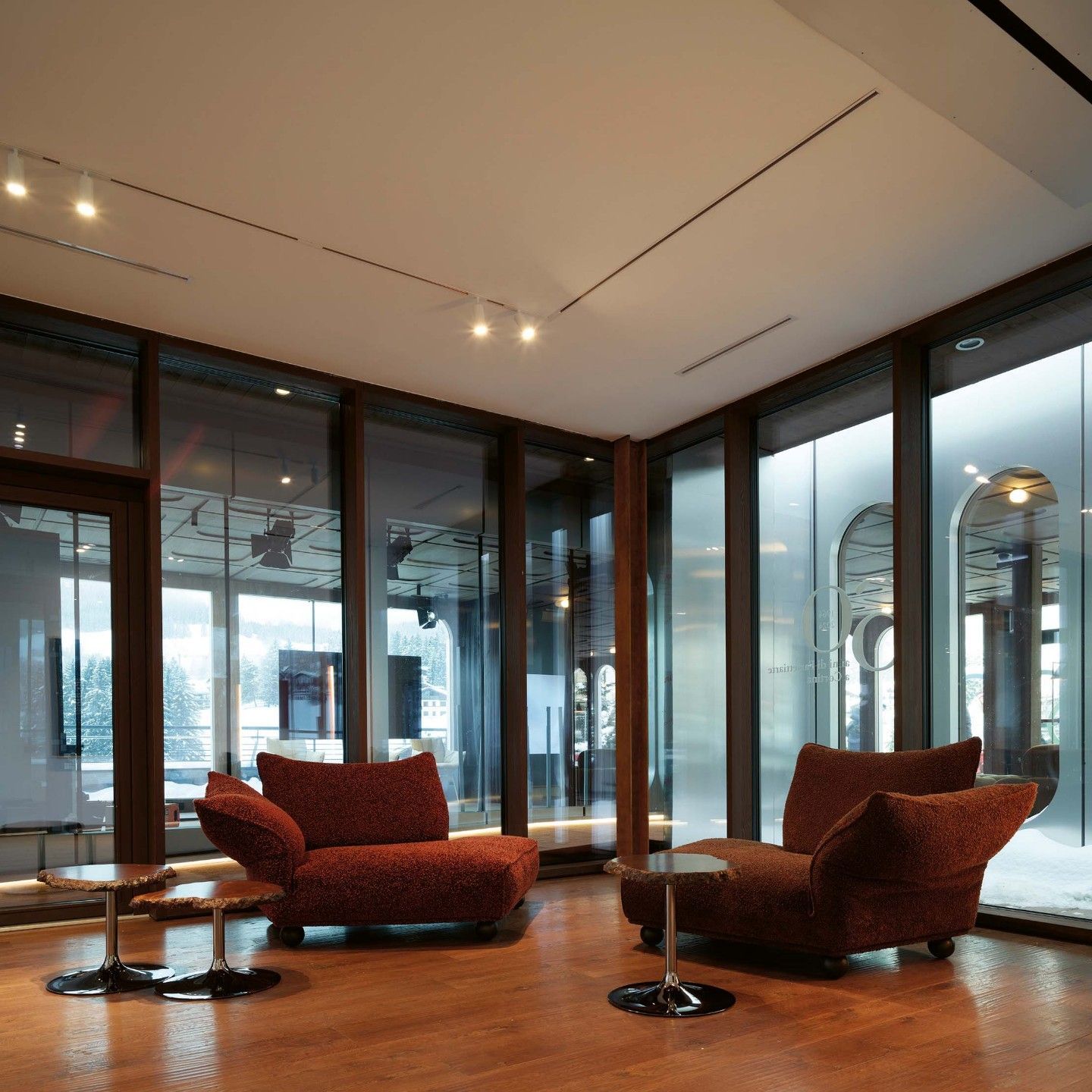  Standway, Cicladi. Il divano in Glossy Matt Burgundy e Coral chaise longue e i tavoli in alabastro ambra offrono un luogo di relax all&rsquo;interno della Galleria Farsettiarte di Cortina d&rsquo;Ampezzo. 