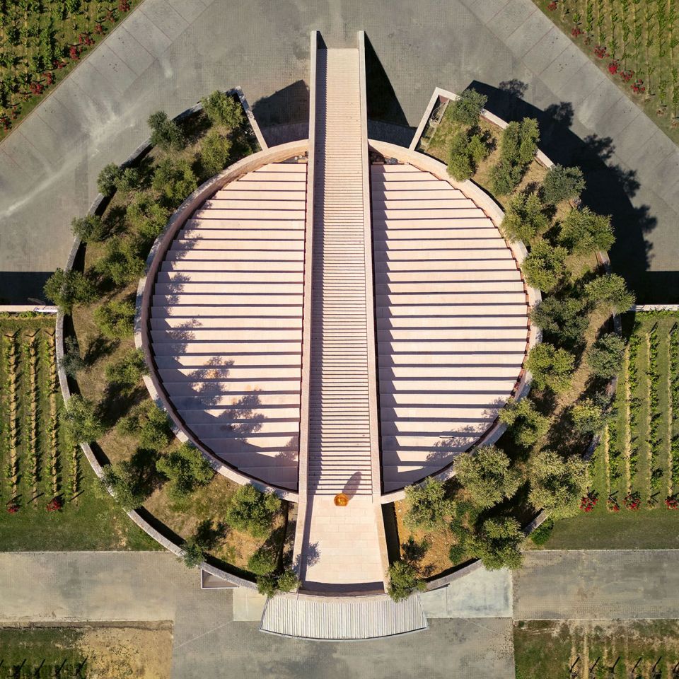  Cantina Petra. La copertura inclinata del cilindro sezionato &egrave; punteggiata da giardini pensili ed &egrave; solcata assialmente da una scenografica scalinata. 